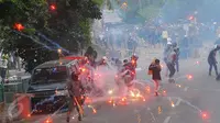 Dua kelompok warga terlibat tawuran di dekat Stasiun Manggarai, Jakarta Selatan, Minggu (8/1). Aparat Kepolisian pun melepaskan gas air mata dan sesekali memberikan tembakan peringatan ke udara untuk meredakan tawuran. (Liputan6.com/Angga Yuniar)