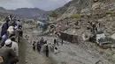 Pejabat polisi Ishrat Khan mengatakan puluhan petugas pemadam kebakaran dan tim penyelamat berusaha menyelamatkan para pengemudi truk dan orang-orang lain yang tertimbun tanah longsor di dekat perbatasan Afghanistan. (AP Photo/Muhammad Sajjad)