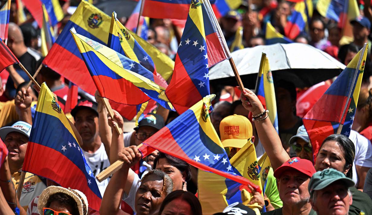 Para pendukung Nicolas Maduro berkumpul di beberapa titik di Caracas untuk memprotes intervensi militer Amerika Serikat. Tampak dalam foto, pendukung mantan Presiden Venezuela, Nicolas Maduro, saat menggelar aksi unjuk rasa di Caracas pada Minggu 4 Januari 2026. (Juan BARRETO/AFP)