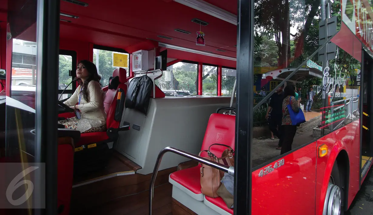 Seorang pramudi bus tingkat wisata TransJakarta mengenakan kebaya saat mengendarai bus tersebut di Jakarta, Jumat (21/4). Dalam rangka Hari Kartini, semua pramudi perempuan bus pariwisata dan Transjakarta mengenakan kebaya. (Liputan6.com/Faizal Fanani)