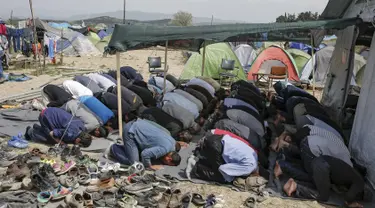 Para imigran terlihat khusyuk saat menggelar salat Jumat di sebuah kamp darurat perbatasan Yunani-Makedonia,desa Idomeni, Yunani (8/4). Meski tengah mencari perlindungan, mereka tak melalaikan kewajibannya sebagai seorang muslim. (REUTERS/Marko Djurica)