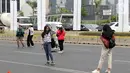 Warga memanfaatkan kondisi lengang sebagian ruas jalan Jenderal Sudirman untuk berfoto, Jakarta, Minggu (27/10/2019). Sebagian ruas Jalan Jenderal Sudirman dialihkan akibat  berlangsungnya Karnaval Kendaraan Listrik yang bertajuk Jakarta Langit Biru. (Liputan6.com/Helmi Fithriansyah)