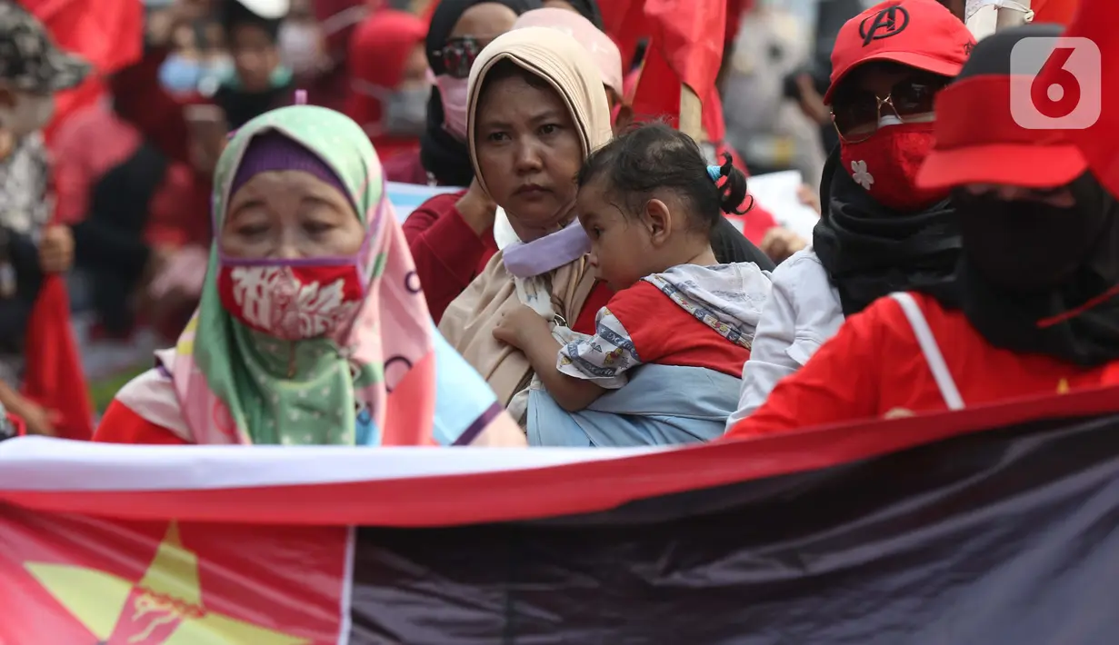 Seorang anak digendong terlihat dalam aksi unjuk rasa menolak UU Omnibus Law Cipta Kerja di Kawasan Patung Kuda, Jakarta, Jumat (16/10/2020). Meski sudah ada imbauan untuk tidak membawa anak-anak dalam aksi unjuk rasa namun sejumlah orang tua tetap menyertakan. (Liputan6.com/Helmi Fithriansyah)