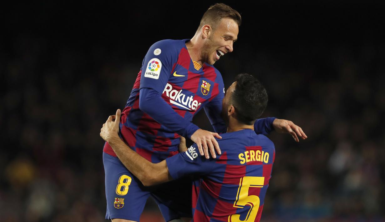 Gelandang Barcelona, Sergio Busquets berselebrasi dengan rekannya Arthur usai mencetak gol ke gawang Celta Vigo pada pertandingan lanjutan La Liga Spanyol di stadion Camp Nou (9/11/2019). Barcelona menang telak 4-1 atas Vigo. (AP Photo/Joan Monfort)