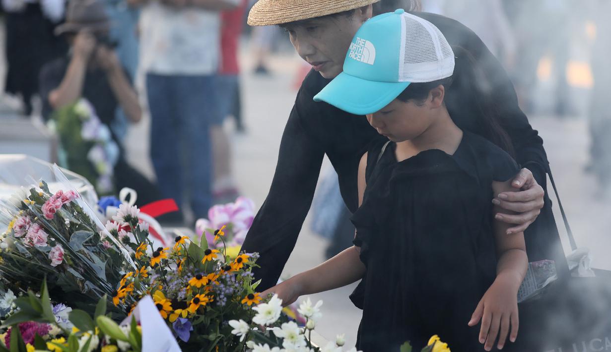 Warga Jepang meletakan bunga sebelum memperingati 72 tahun tragedi bom Hiroshima di Peace Memorial Park di Hiroshima, Jepang (6/8). Acara peringatan tragedi bom atom Hiroshima ini digelar setiap tahun. (AFP Photo/Jiji Press/STR)