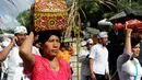 Umat Hindu membawa sesajen sebelum berdoa saat perayaan Kuningan di sebuah pura di Pulau Serangan, Denpasar, Bali, Sabtu (20/2). Kuningan merupakan hari terakhir dari perayaan Galungan. (AFP PHOTO/SONNY Tumbelaka)