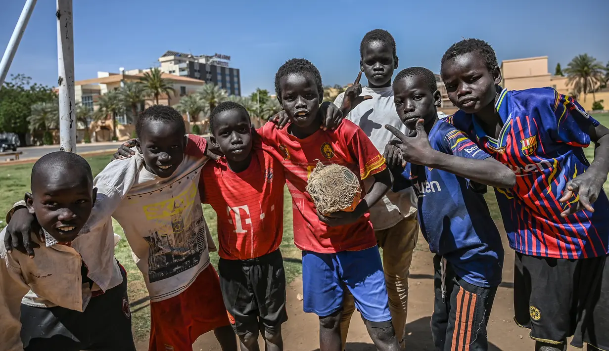 Sejumlah anak Sudan berpose sebelum bermain sepak bola di ibu kota Khartoum (23/4). Negara ini berbatasan dengan Mesir di utara, Laut Merah di timur laut, Kongo dan Afrika Tengah di barat daya, Chad di barat, dan Libya di barat laut. (AFP Photo/Ozan Kose)