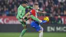 Bek Atletico Madrid, Jose Gimenez (kiri) berebut bola dengan striker Girona, rtem Dovbyk pada laga pekan ke-19 Liga Spanyol 2023/2024 di Montilivi Stadium, Girona, Kamis (4/1/2024) dini hari WIB. (AFP/Pau Barrena)