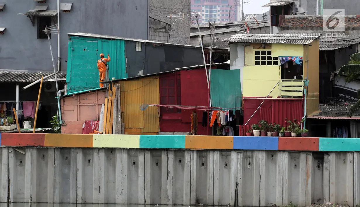 Petugas Penanganan Prasarana dan Sarana Umum (PPSU) mengecat rumah warga yang berada di pinggir Danau Sunter Jakarta, Kamis (22/3). (Liputan6.com/Arya Manggala)