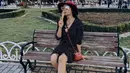 Febby Rastanty mengenakan mini dress hitam kerah v neck lengan pump 3/4. Dipadukan sepatu Prada hitam, serta mini bag dan topi merahnya. @febbyrastanty