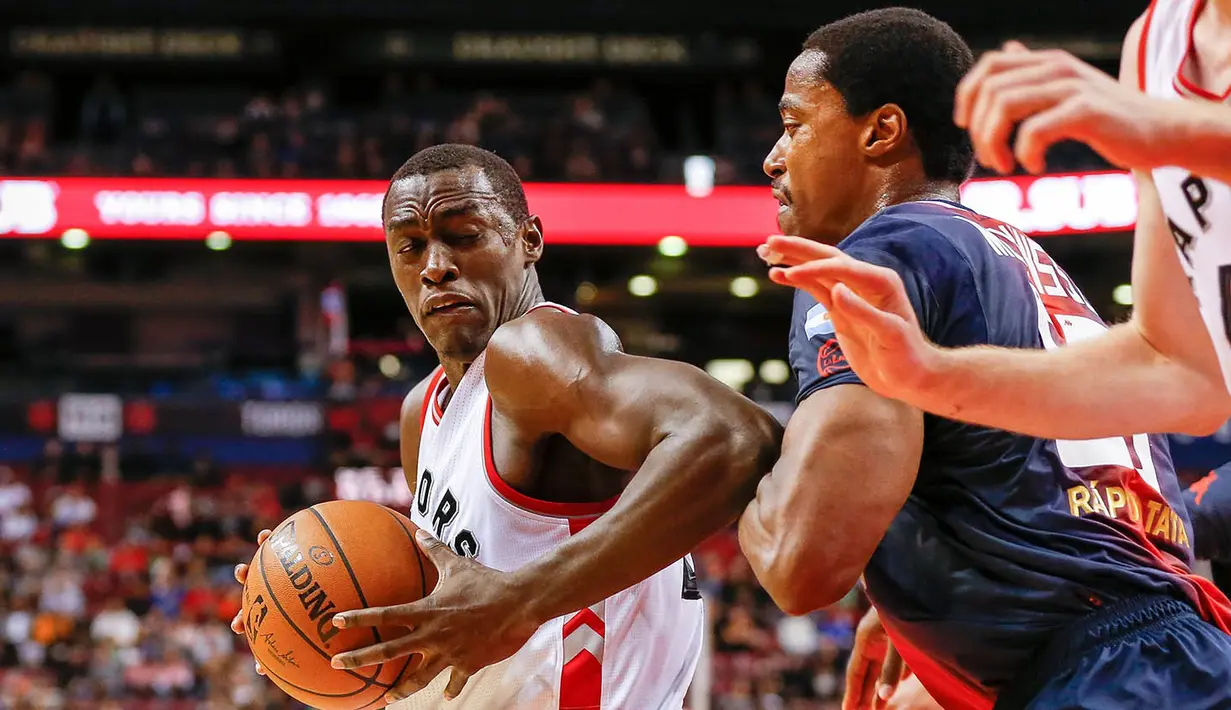 Forward Toronto Raptors, Pascal Siakam, berusaha melewati pebasket San Lorenzo, Jerome Meyinsse, pada laga pramusim NBA di Rogers Center, Toronto, Sabtu (15/10/2016). Raptors menang 122-105 atas San Lorenzo. (USA Today Sports/Kevin Sousa)