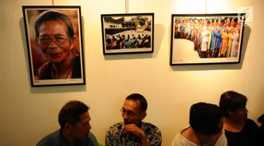 Pengunjung berbincang di depan deretan foto yang dipamerkan saat Peluncuran Buku Danau Toba dan Mangongkal Holi di Jakarta, Kamis (24/8). Pameran foto menampilkan kehidupan masyarakat dan budaya Batak. (LIputan6.com/Helmi Fithriansyah)