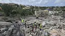 Para pekerja pertahanan sipil Lebanon menyisir reruntuhan, sehari setelah serangan Israel di desa Deir Qanun al-Nahr, Lebanon Selatan, pada Rabu 20 Mei 2026. (KAWNAT HAJU/AFP)