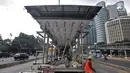 Pekerja menyelesaikan proyek perluasan Halte Bus Transjakarta Gelora Bung Karno (GBK) di Jalan Jenderal Sudirman, Jakarta, Selasa (24/7). (Liputan6.com/Faizal Fanani)