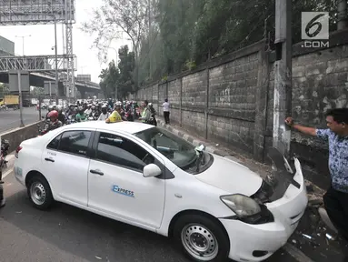 Pengendara sepeda motor tersendat saat melintasi lokasi kecelakaan taksi menabrak tiang di Jalan Ahmad Yani, Jakarta, Rabu (1/8). Kecelakaan terjadi setelah sopir taksi berusaha menghindari pengendara sepeda motor di depannya. (Merdeka.com/Iqbal Nugroho)