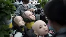 Para pekerja melukis wajah boneka seks di pabrik EXDOLL, sebuah perusahaan yang terletak di Dalian, China, Kamis (1/2). Selain bisa berbicara, boneka seks ini juga bisa bermain musik dan menyalakan mesin pencuci piring. (AFP PHOTO/FRED DUFOUR)