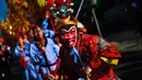 Ekspresi seorang pria yang mengenakan kostum dan topeng kera saat perayaan menjelang tahun baru China di Lisbon, Portugal (21/1).  Pada tahun baru imlek 2017 ini memasuki tahun Ayam Jantan. (AFP/Patricia De Melo Moreira)
