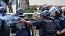 Polisi juga menggunakan peluru karet, gas air mata, meriam air, dan pentungan untuk menghalau pengunjuk rasa yang akan menerobos kawat berduri dan mencoba menyerbu area terbatas di dekat gedung parlemen. (PRABIN RANABHAT/AFP)