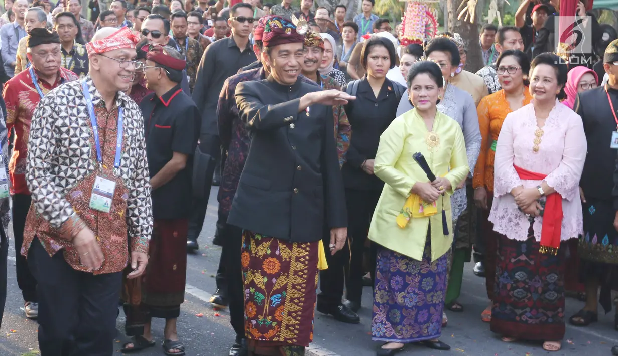Presiden Joko Widodo dan Ibu Negara Iriana mengenakan pakaian adat Bali tiba menghadiri Karnaval Budaya Bali, Jumat (12/10). Karnaval tersebut untuk mengenalkan kepada delegasi  IMF - WB Group 2018 tentang budaya Bali. (Liputan6.com/Angga Yuniar)