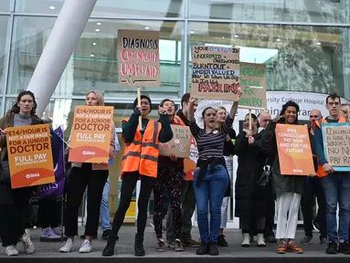 Para pekerja Layanan Kesehatan Nasional (National Health Service/NHS) memegang plakat di garis piket di luar Rumah Sakit University College di pusat kota London pada 20 September 2023. (JUSTIN TALLIS/AFP)