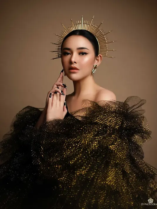 Wajah dirias dengan riasan yang bold; winged eyeliner yang mempercantik area matanya dan riasan glowing bernuansa oranye yang pas secara keseluruhan dengan penampilannya. [Foto: Instagram/fdphotography90]