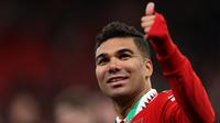 Gelandang Manchester United,Casemiro memberi isyarat kepada para pendukung selama perayaan juara Carabao Cup 2022/2023 mengalahkan Newcastle United pada laga final di Stadion Wembley di London, Senin dini hari WIB (27/2/2023). Kemenangan ini menuntun MU jadi juara EFL Cup/Carabao Cup 2022-2023. Trofi pertama di era Ten Hag. (AFP/GLYN KIRK)