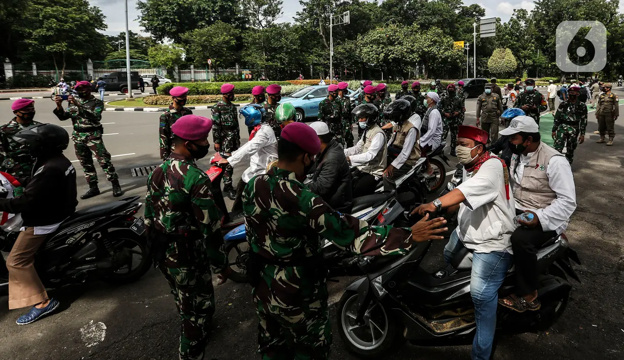 Aksi prajurit TNI menghalau massa yang hendak menggelar demonstrasi 1812 di sekitar Istana Negara, Jakarta, Jumat (18/12/2020). Aparat yang bertugas mencoba memberi tahu massa Aksi 1812 mengingat Jakarta masih dalam situasi pandemi Covid-19. (Liputan6.com/Johan Tallo)