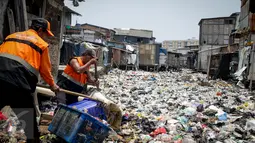 Petugas mengangkut sampah yang menumpuk di Kali Gendong, Penjaringan, Jakarta Utara, Kamis (16/3). Ceceran sampah plastik limbah rumah tangga terlihat menyerupai daratan menumpuk di sepanjang Kali Gendong. (Liputan6.com/Faizal Fanani)