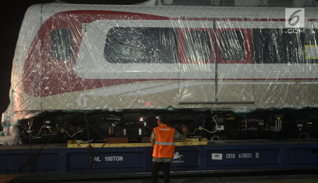 Pekerja mengecek gerbong kereta ringan/Light Rail Transit (LRT) yang baru tiba di Pelabuhan Car Terminal, Tanjung Priok, Jakarta, Jumat (13/4).  Dua gerbong kereta LRT yang diangkut itu merupakan yang pertama tiba di Jakarta. (Merdeka.com/Imam Buhori)