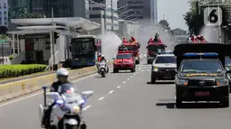 Mobil pemadam dari Dinas Pemadam Kebakaran Pemprov DKI melakukan penyemprotan cairan disinfektan di Jalan Thamrin, Jakarta, Selasa (31/3/2020). Penyemprotan yang dilakukan terus menerus itu untuk meminimalisir penyebaran COVID-19 di ruang udara dan ruas jalan. (Liputan6.com/Faizal Fanani)