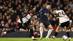 Pemain Tottenham Hotspur, Son Heung-Min, berusaha melewati pemain Fulham pada laga Liga Inggris di Stadion Craven Cottage, Minggu (17/3/2024). Kekalahan ini membuat Spurs membuang kesempatan untuk menembus empat besar klasemen. (AFP/Henry Nicholis)