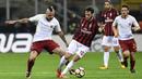 Gelandang AC Milan, Hakan Calhanoglu, berebut bola dengan gelandang AS Roma, Radja Nainggolan, pada laga Serie A Italia di Stadion San Siro, Milan, Minggu (1/10/2017). Milan kalah 0-2 dari Roma. (AFP/Miguel Medina)