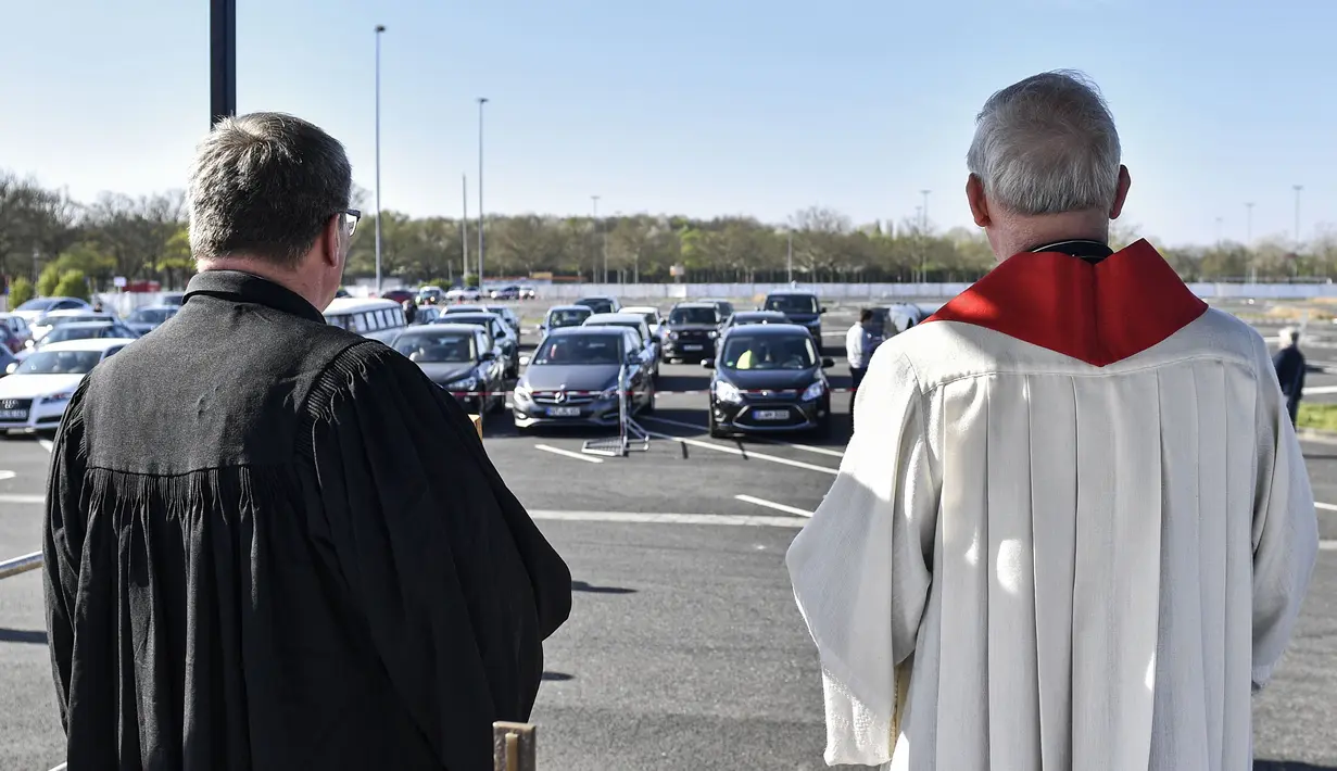 Pastor Frank Heidkamp (kanan) dan Evangelis Heinrich Fuchs saat kebaktian Jumat Agung di sebuah bioskop drive-in di Duesseldorf, Jerman, Jumat (10/4/2020). Kebaktian drive-in dilakukan usai Jerman menutup semua tempat ibadah untuk mencegah penyebaran virus corona COVID-19. (AP Photo/Martin Meissner)