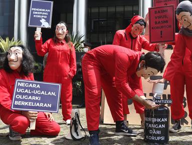 Sejumlah aktivis Indonesia Corruption Watch (ICW) dan Gerakan #BersihkanIndonesia melakukan aksi teatrikal saat unjuk rasa di depan Gedung KPK, Jakarta, Rabu (8/12/2021). Aksi dalam rangka memperingati Hari Anti Korupsi Sedunia pada 9 Desember 2021. (Liputan6.com/Herman Zakharia)