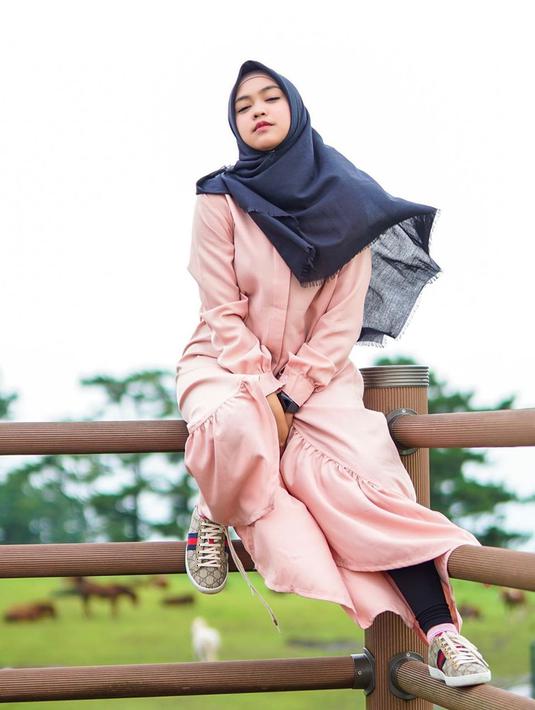 Youtuber dengan jumlah subscriber terbanyak kedua di Indonesia ini tampak santai saat liburan di Korea. Menggunakan busana muslim berwarna pink, dilengkapi dengan hijab berwarna hitam yang dihembus angin, ia tampak menawan. (Liputan6.com/IG/@riaricis1795)
