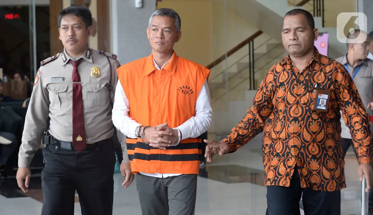 Komisioner KPU Wahyu Setiawan (rompi tahanan) dikawal petugas seusai menjalani pemeriksaan di gedung KPK, Jakarta, Rabu (15/1/2020). Wahyu Setiawan diperiksa perdana setelah ditetapkan sebagai tersangka terkait dugaan penerimaan suap penetapan anggota DPR terplih 2019-2020. (merdeka.com/Dwi Narwoko)