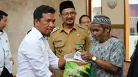 Ketua PWI Garut Ari Maulana Karang disaksikan Wakil Bupati Garut Helmi Budiman, memberikan paket sembako bagi warga Garut, dalam bakti sosial rangkain HPN di Garut. (Liputan6.com/Jayadi Supriadin)