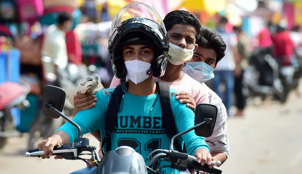 Pengendara motor terlihat di sepanjang jalan di Chowk, Allahabad, Senin (17/8/2020). Kasus kematian akibat Covid-19 di India telah melewati 50 ribu pada Senin (17/8), dengan kawasan pedesaan dan kota kecil yang lemah dalam sistem kesehatan menjadi daerah terdampak paling parah. (SANJAY KANOJIA/AFP)