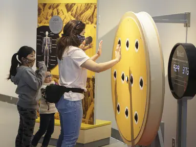 Seorang pekerja garis depan dan dua orang anak mengunjungi Science World di Vancouver, British Columbia, Kanada (23/7/2020). Science World Vancouver menawarkan tiket masuk gratis bagi para pekerja yang berjuang di garis depan melawan pandemi COVID-19 dan anggota keluarga mereka. (Xinhua/Liang Sen)