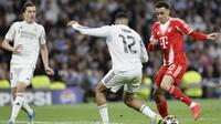 Gelandang Jerman Bayern Munich #10, Jamal Musiala (kanan), dan bek Inggris Real Madrid #12, Trent Alexander-Arnold, berebut bola selama pertandingan leg pertama perempat final Liga Champions UEFA antara Real Madrid dan Bayern Munchen di Stadion Santiago Bernabeu di Madrid pada 8 April 2026. (Oscar DEL POZO/AFP)