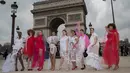 Sejumlah wanita yang tergabung dalam plus size models atau model ukuran plus berpose di depan Triump Arch di Paris, Prancis (4/1). Meraka melakukan catwalk di ruang publik dengan mengenakan busana layaknya di sebuah acara fashion show. (AFP/Thomas Samson)