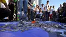Sejumlah orang menggelar aksi "Koin Untuk Australia" di Bundaran HI, Minggu (22/2). Aksi itu sebagai bentuk protes terhadap penyataan PM Australia Tony Abott yang mengungkit bantuan kepada Indonesia saat musibah tsunami Aceh. (Liputan6.com/Faizal Fanani)