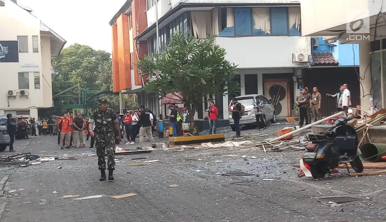 Petugas berjalan dekat puing-puing di lokasi ledakan yang terjadi di kawasan Ruko Grand Wijaya, Kebayoran Baru, Jakarta Selatan, Kamis (12/7). Meski tidak menyebabkan korban jiwa, ledakan dilaporkan melukai dua orang korban. (Liputan6.com/Ady Anugrahadi)