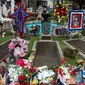 Karangan bunga beserta poster Elvis Presley memenuhi makam sang bintang rock n roll itu di Graceland, Memphis, Tennessee, Selasa (16/8). Elvis Presley menjadi salah satu ikon budaya paling penting di abad ke-20. (AP Photo/Brandon Dill)
