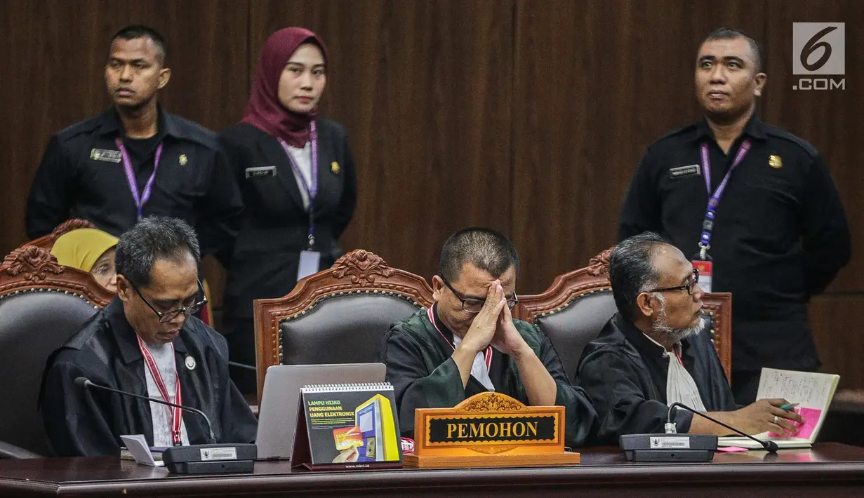 Wakil Tim Hukum Prabowo-Sandiaga, Denny Indrayana (tengah) menundukkan kepala usai putusan MK di Gedung MK, Jakarta, Kamis (27/6/2019). MK menolak seluruh gugatan hasil Pilpres 2019 yang diajukan Prabowo-Sandiaga Uno yang disepakati 9 hakim konstitusi. (Liputan6.com/Faizal Fanani)