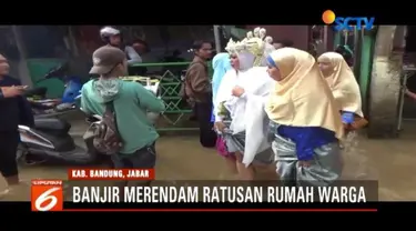 Banjir masih melanda sejumlah wilayah Jawa Barat. Namun banjir yang merendam tidak menyurutkan warga Dayeuhkolot untuk menggelar resepsi pernikahan.