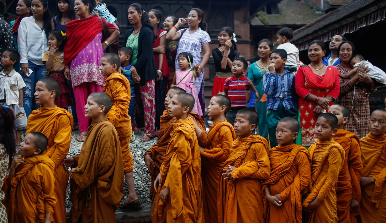 Sejumlah biksu cilik menyaksikan patung jerami Ghanta Karna yang dibakar di Bhaktapur di pinggiran Kathmandu, Nepal (21/7). Tradisi ini juga melambangkan musnahnya kejahatan di kota Bhaktapur. (AFP Photo/Uma Bista)