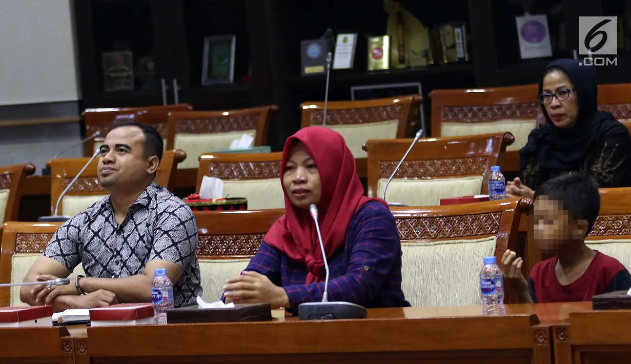 Terpidana kasus pelanggaran UU ITE sekaligus korban pelecehan seksual Baiq Nuril (tengah) berbicara dalam rapat pleno Komisi III DPR di Gedung Nusantara III, Jakarta, Rabu (23/7/2019). Baiq Nuril ditemani anak laki-lakinya dan kuasa hukum Yan Mangandar Putra. (Liputan6.com/JohanTallo)