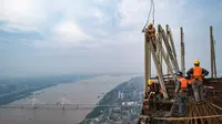Sejumlah pekerja konstruksi bekerja di ketinggian sekitar 500 meter di lokasi pembangunan sebuah bangunan bertingkat tinggi di Wuhan, Provinsi Hubei, China tengah (11/8/2020). Para pekerja konstruksi harus menghadapi ketinggian dan panasnya udara musim panas. (Xinhua/Xiao Yijiu)