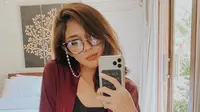Aksesoris kacamata dengan frame cukup besar seperti yang digunakan Nana Mirdad mungkin bisa menjadi pilihan saat melakukan mirror selfie. Selain menunjukan detail penampilan, kacamata tersebut juga bisa menjadi item meski tak menggunakan makeup. (Liputan6.com/IG/@nanamirdad_)